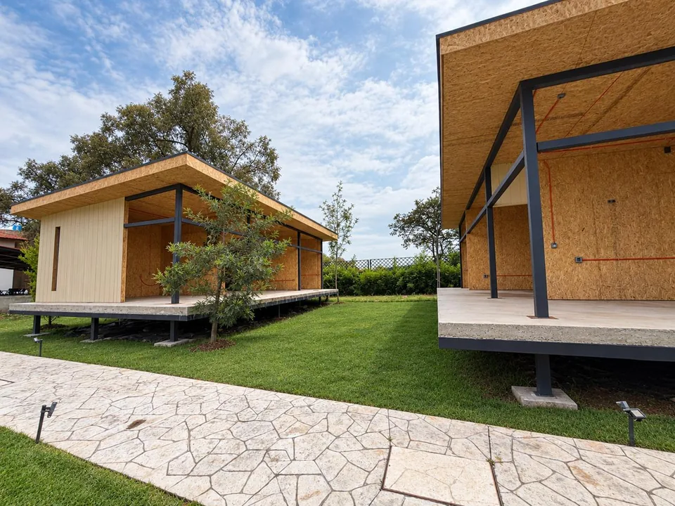 Conjunto residencial de pabellones con caminos de piedra y jardín.